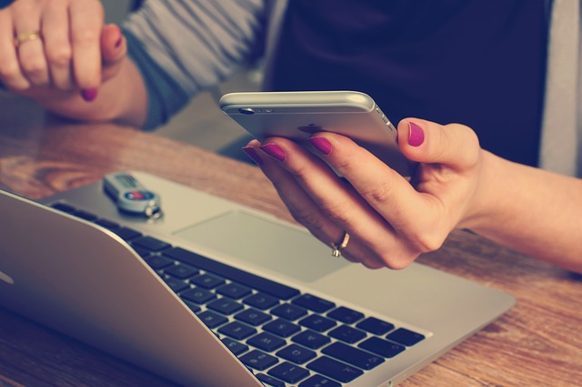 Girl using a phone and laptop 